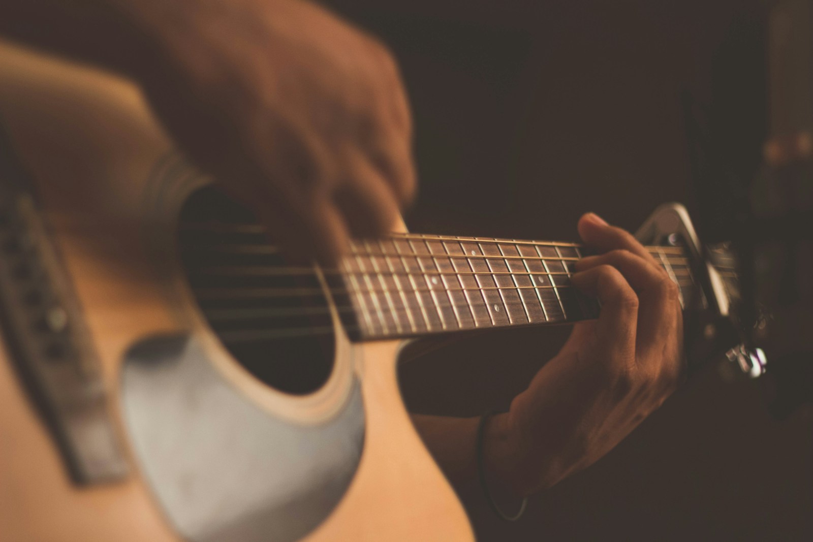 Hand-carved acoustic guitar body with curly maple top in luthier workshop with wood shavings